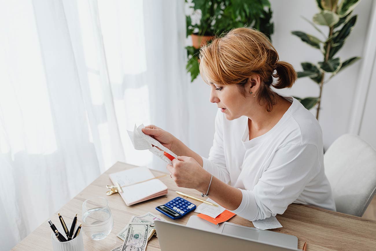 Professional woman in white reviewing documents at a bright modern office desk