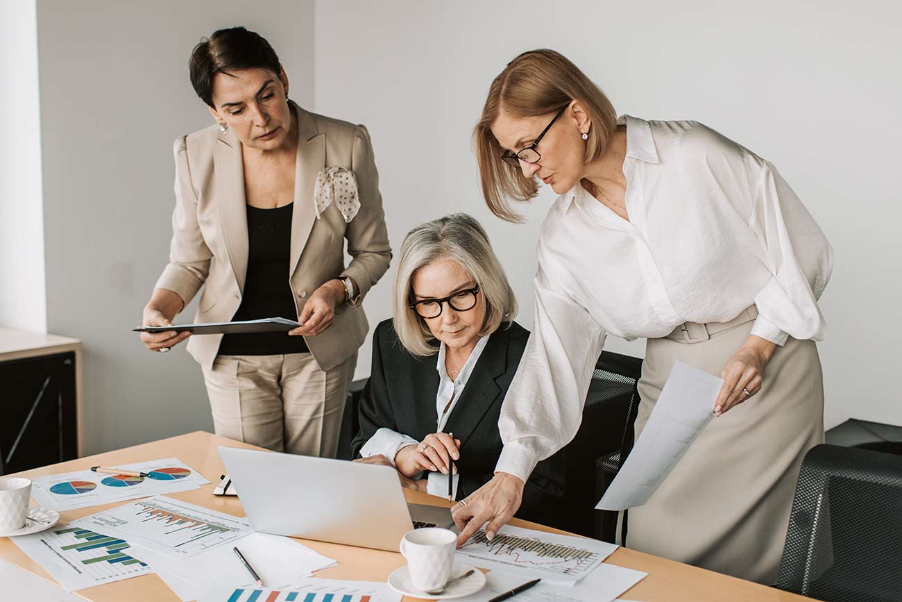 Professional woman in white reviewing documents at a bright modern office desk