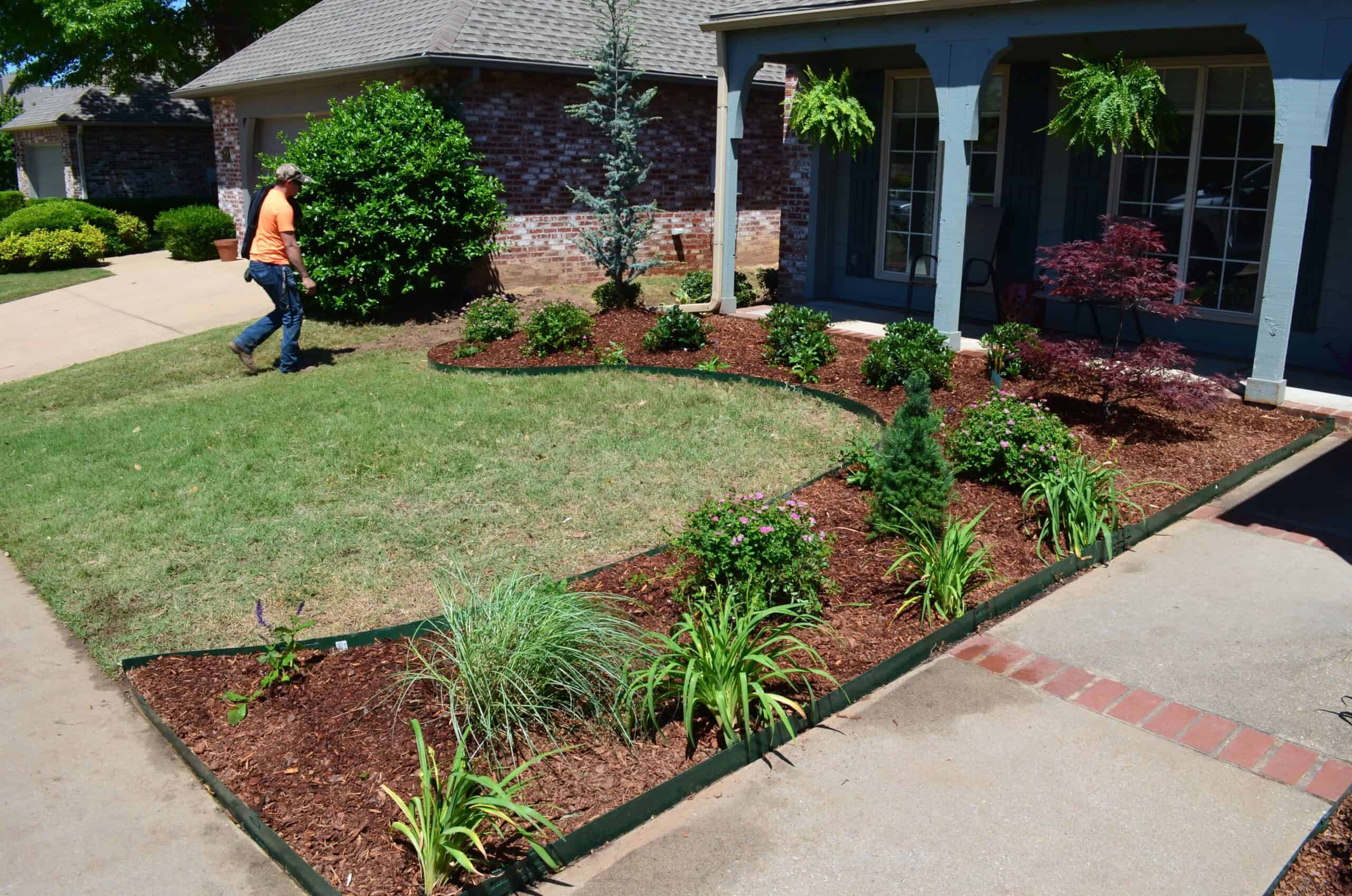 Custom landscape design with mulched garden beds and decorative stepping stone pathway