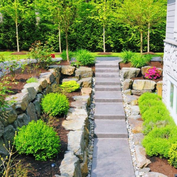 Hardscape Design featuring a stone garden pathway through lush ornamental plantings
