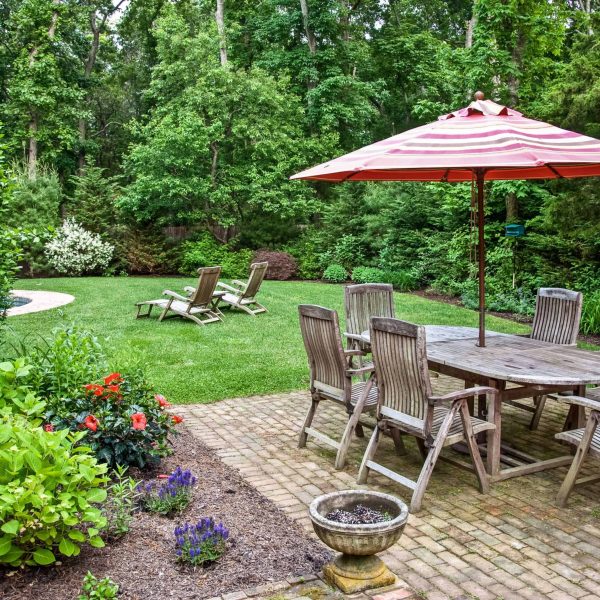 Backyard landscape installation with outdoor dining patio and vibrant garden beds
