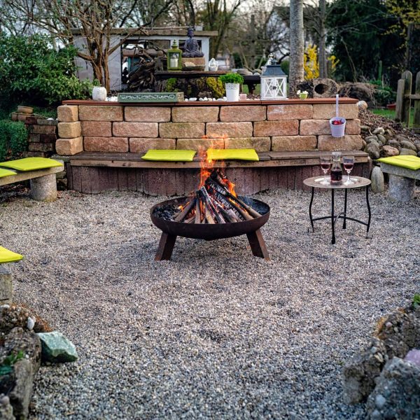 Backyard landscape design featuring a fire pit seating area with gravel ground cover