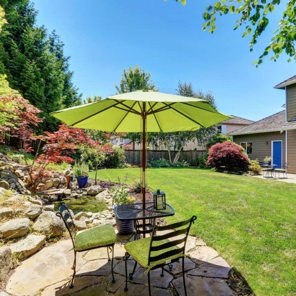 Professional landscape design featuring a backyard patio with dining area and garden